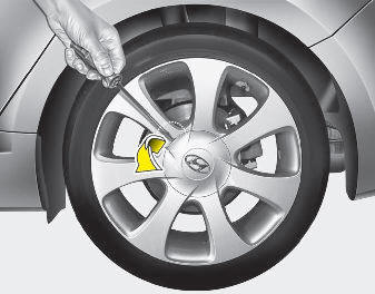 6. Insert the screwdriver into the groove of the wheel cap and pry gently to