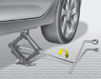 9. Insert the jack handle into the jack and turn it clockwise, raising the vehicle